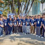 a group of young people posing for a photo outdoors