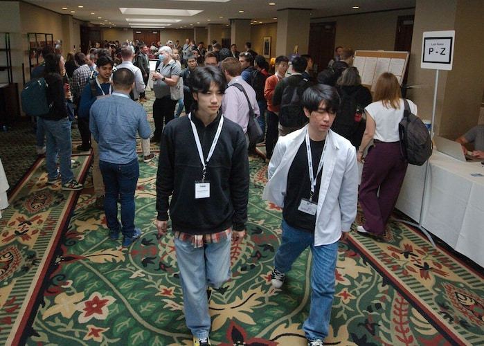 A diverse group of individuals walking together in a well-lit hallway, engaged in conversation