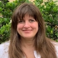 a woman with long brown hair smiling