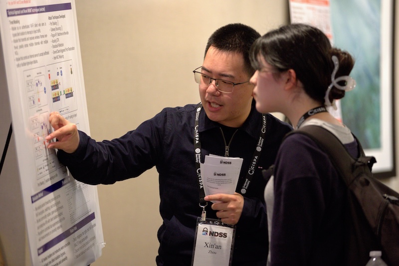 two people discussing while pointing at a poster
